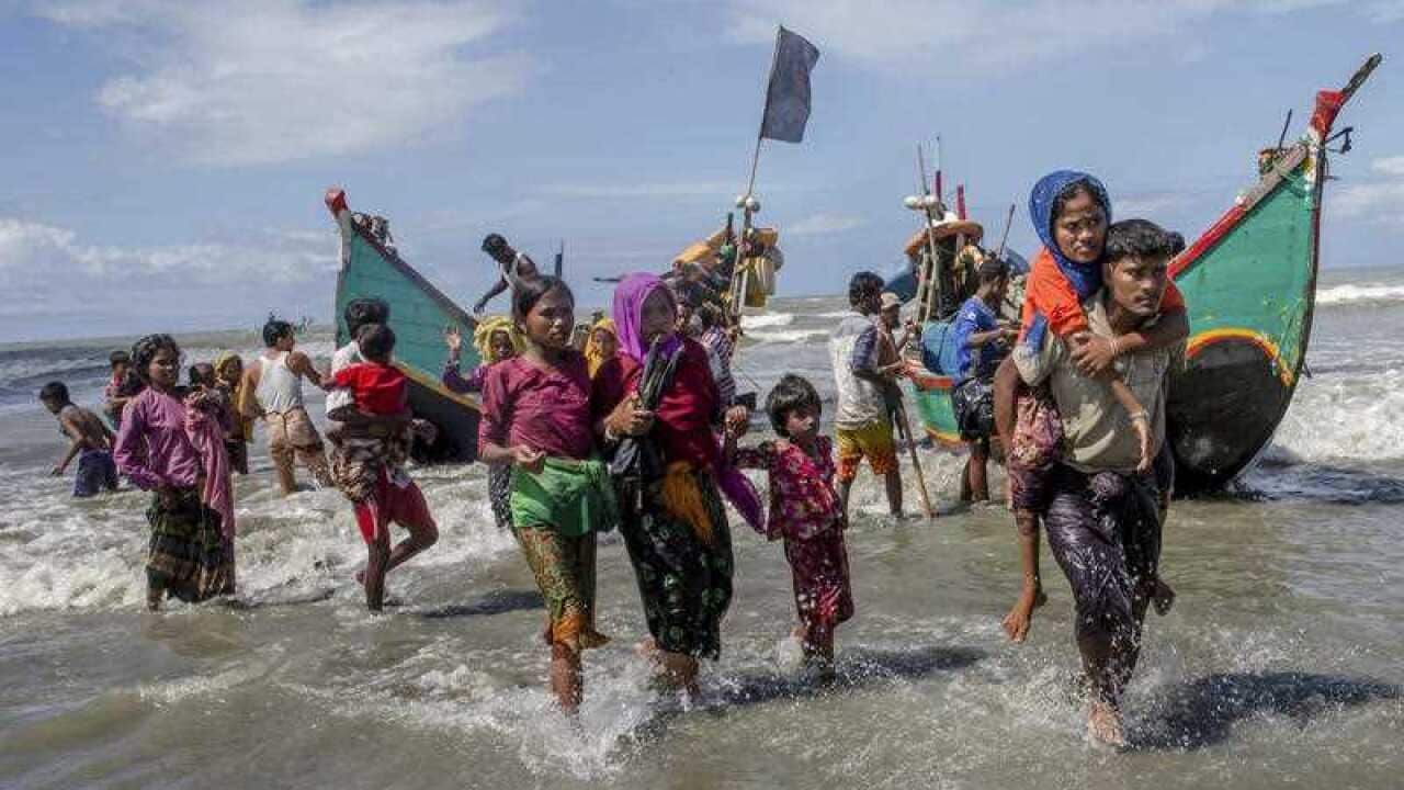 Rohingya Muslims walk to the shore after arriving on a boat from Myanmar to Bangladesh in Shah Porir Dwip, Bangladesh, Thursday, Sept. 14, 2017.
