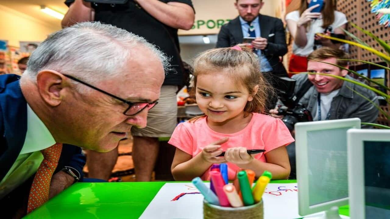 Australian PM Malcolm Turnbull inspects a child's drawing in Sydney.