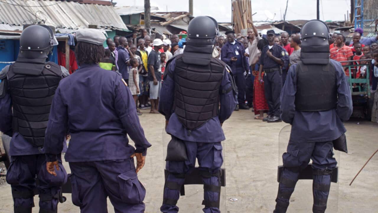 Liberian security forces stop people from leaving a slum area