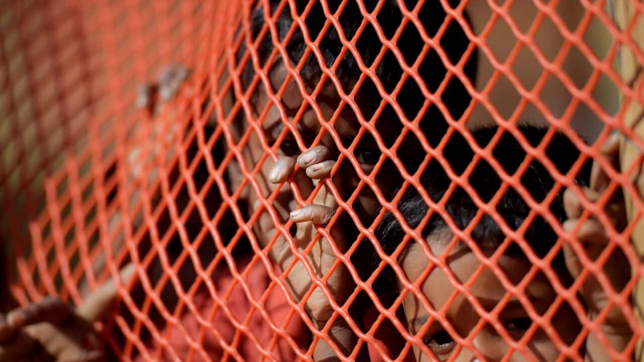 Rohingya children look through the mesh enclosure of a child-safe area at the Balukhali refugee camp near Cox's Bazar in Bangladesh on Tuesday, December 12, 2017. More than 646,000 Rohingya refugees have crossed the border from Myanmar into Bangladesh, fo