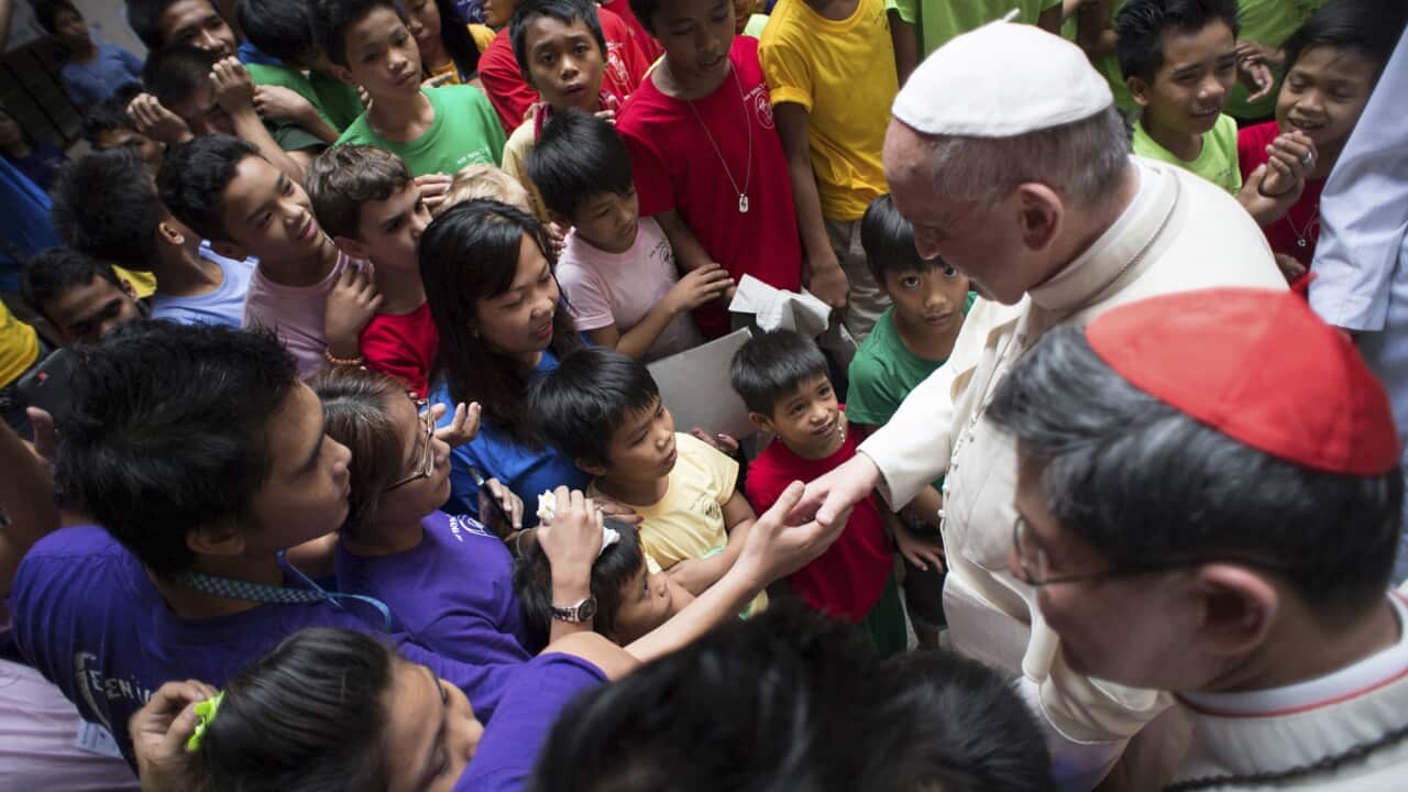 Pope Francis salutes children of the Anak-Tnk Foundation, which helps those living in the slums in Manila's Intramuros district, Friday, Jan. 16, 2015. (AP Photo/Osservatore Romano, Pool)