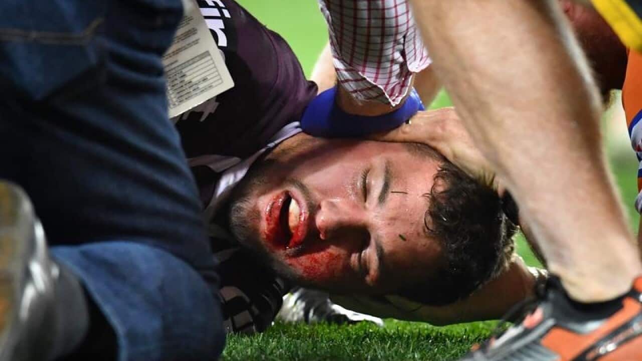 Corey Oates of the Broncos lies injured on the field