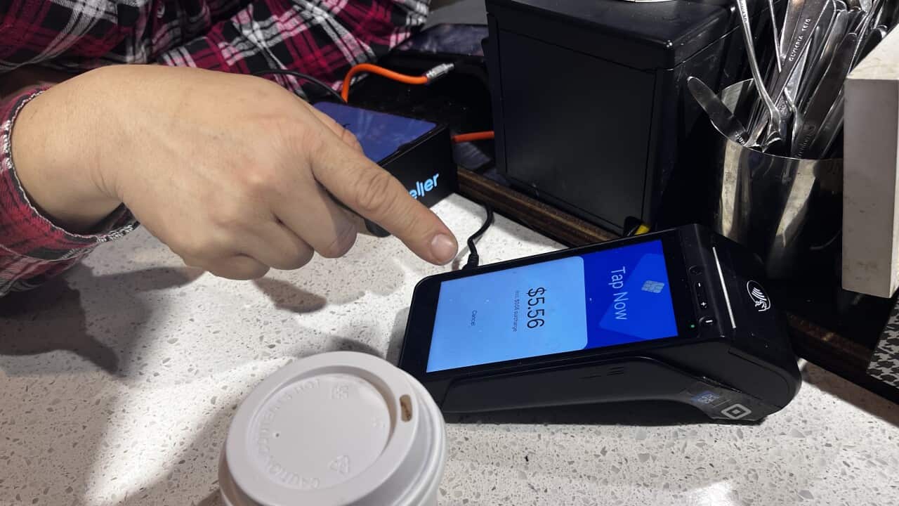 A person points to an EFTPOS machine