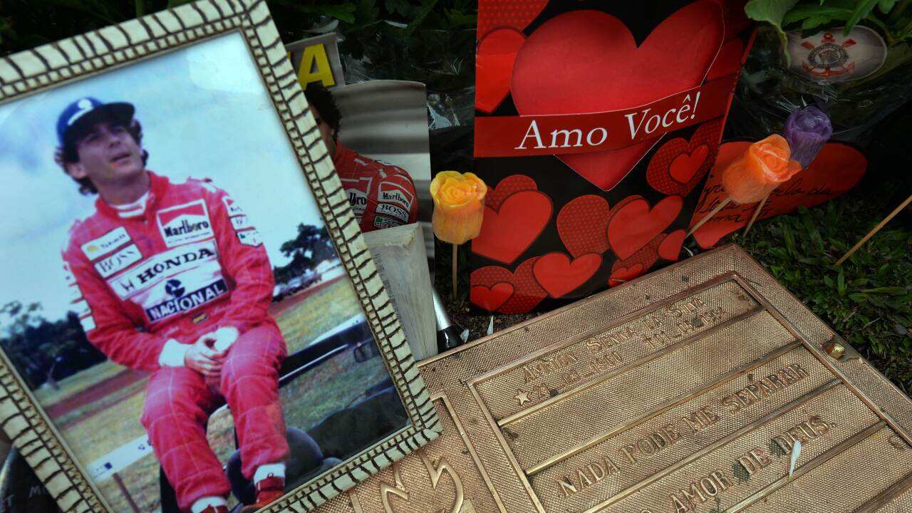 A photo of Brazilian's F1 driver Ayrton Senna is seen among flowers left by fans in his grave in Sao Paulo, Brazil on May 1, 2014, paying tribute to the 20th anniversary of his death during the 1994 San Marino Grand Prix. AFP PHOTO / Nelson ALMEIDA