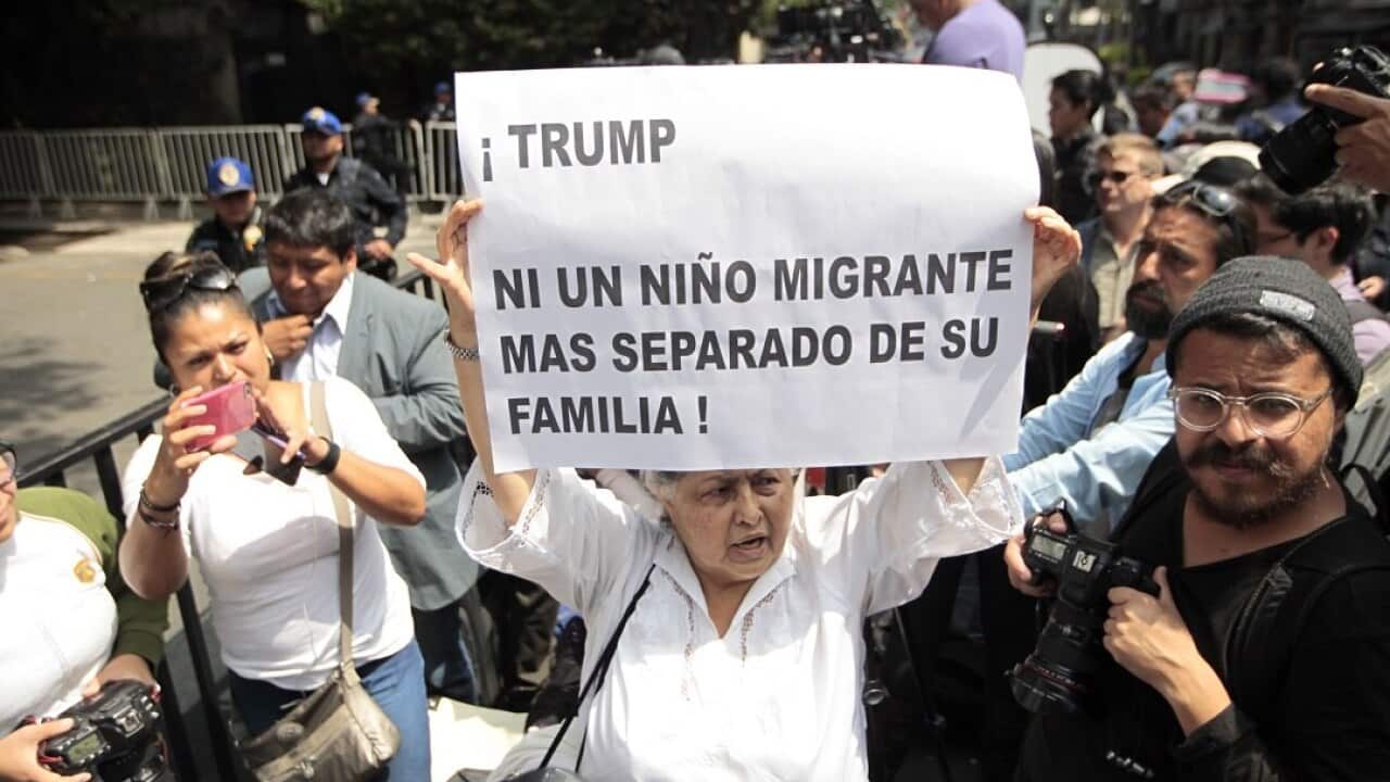 A protester holds a sign that reads 'Trump not one more migrant child separated from his family' as Mike Pompeo visits Mexico.