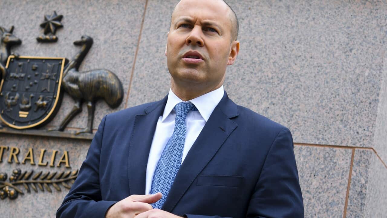 Treasurer Josh Frydenberg is seen standing in front of the Treasury building.