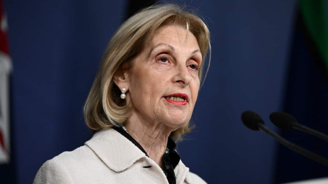 A woman with short blonde hair speaks during a press conference outside.