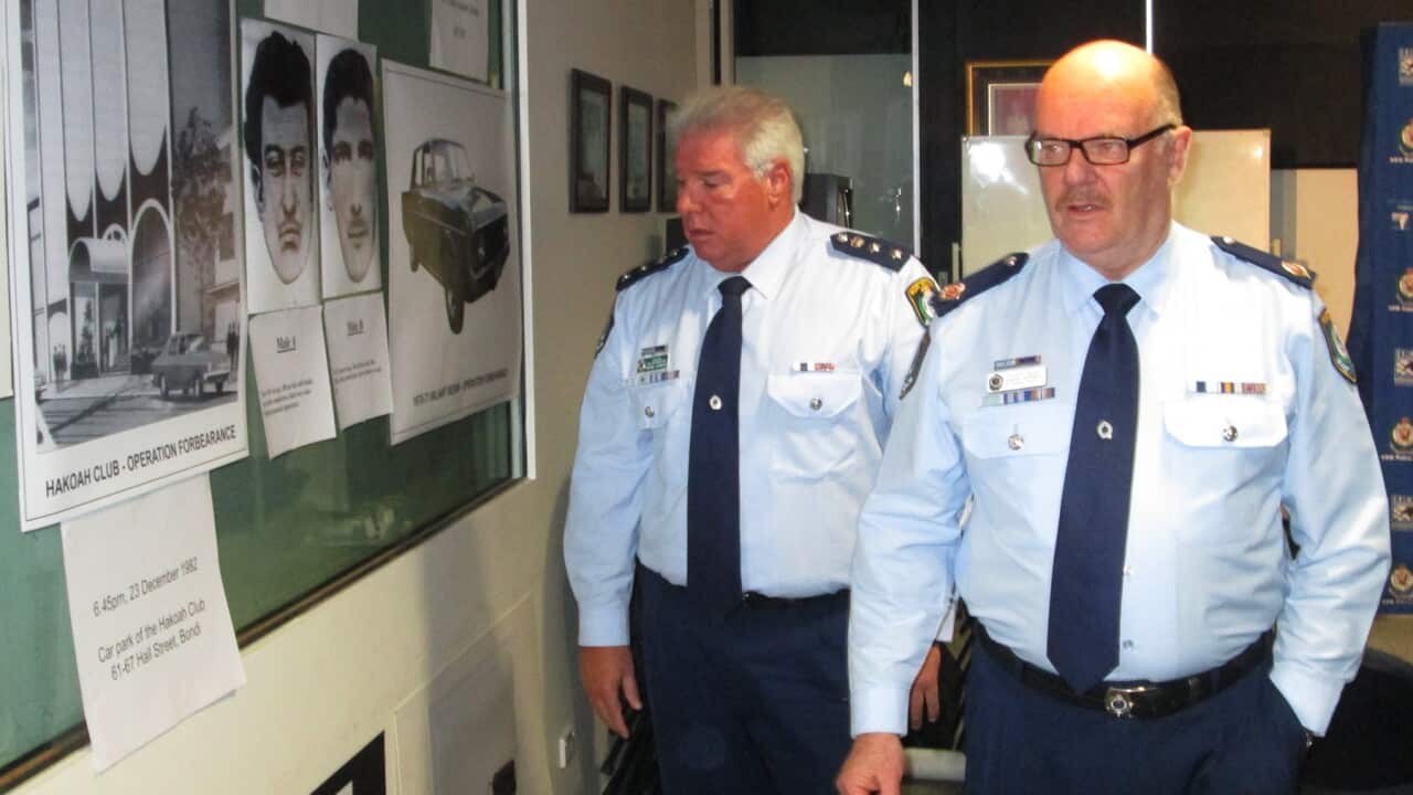Senior police at their headquarters looking at suspect pictures and photos on a wall (AAP).jpg