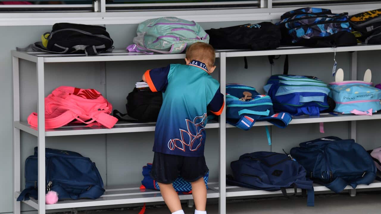 A young child looking through his schoolbag