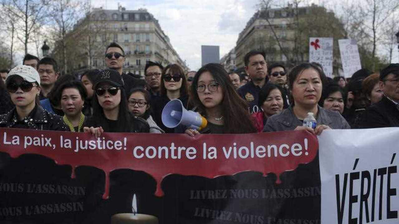People from the Chinese community holds a banner reading " For peace and justice, against violence" as they protest over the fatal shooting of Shaoyo Liu