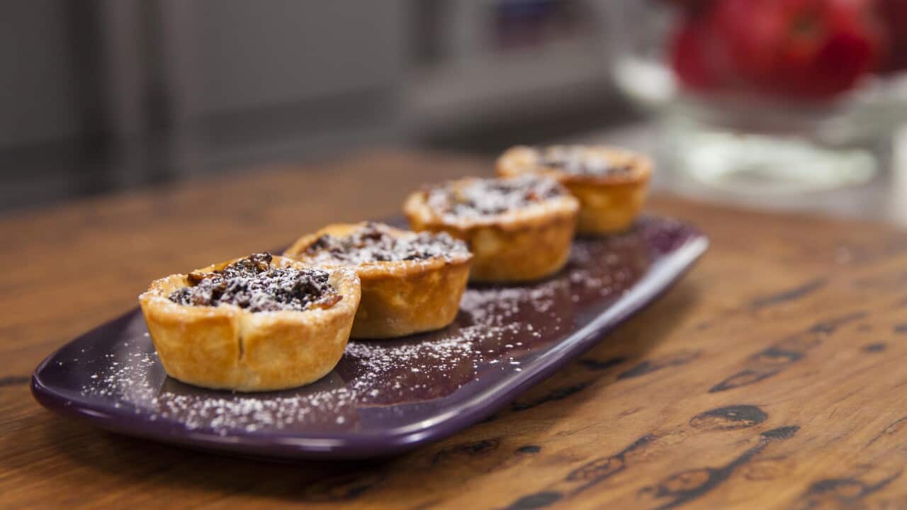 Four small round tarts sit on a purple platter.