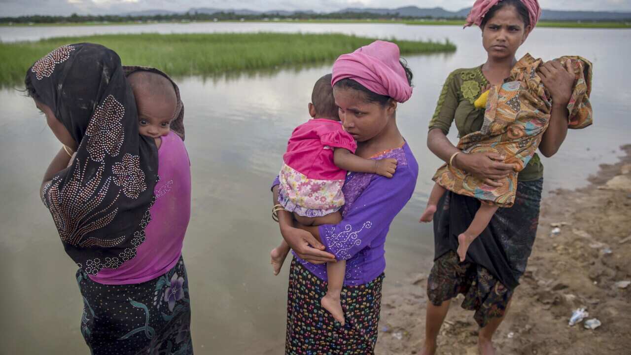 Rohingya Muslim women and their children cross over from Myanmar to Bangladesh. Many are at risk from colossal impacts of floods, cyclones and other environmental disasters linked to climate change