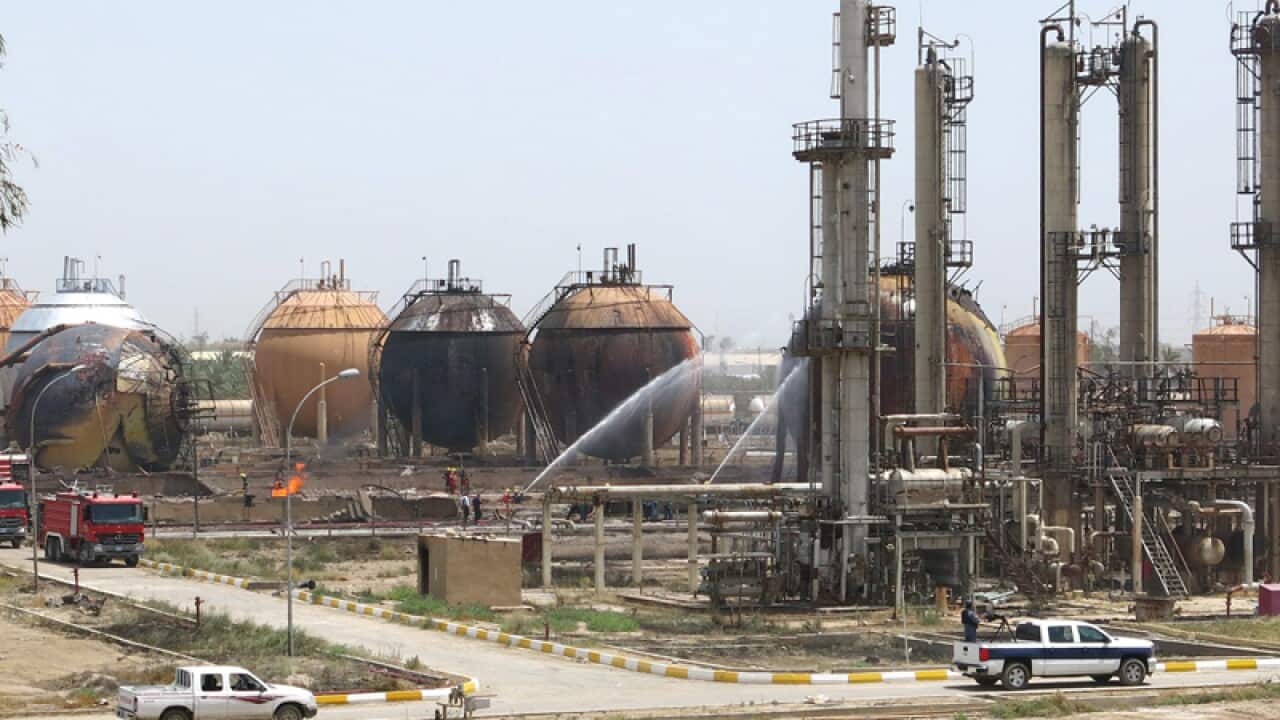 Firefighters try to extinguish a fire at the Taji gas factory