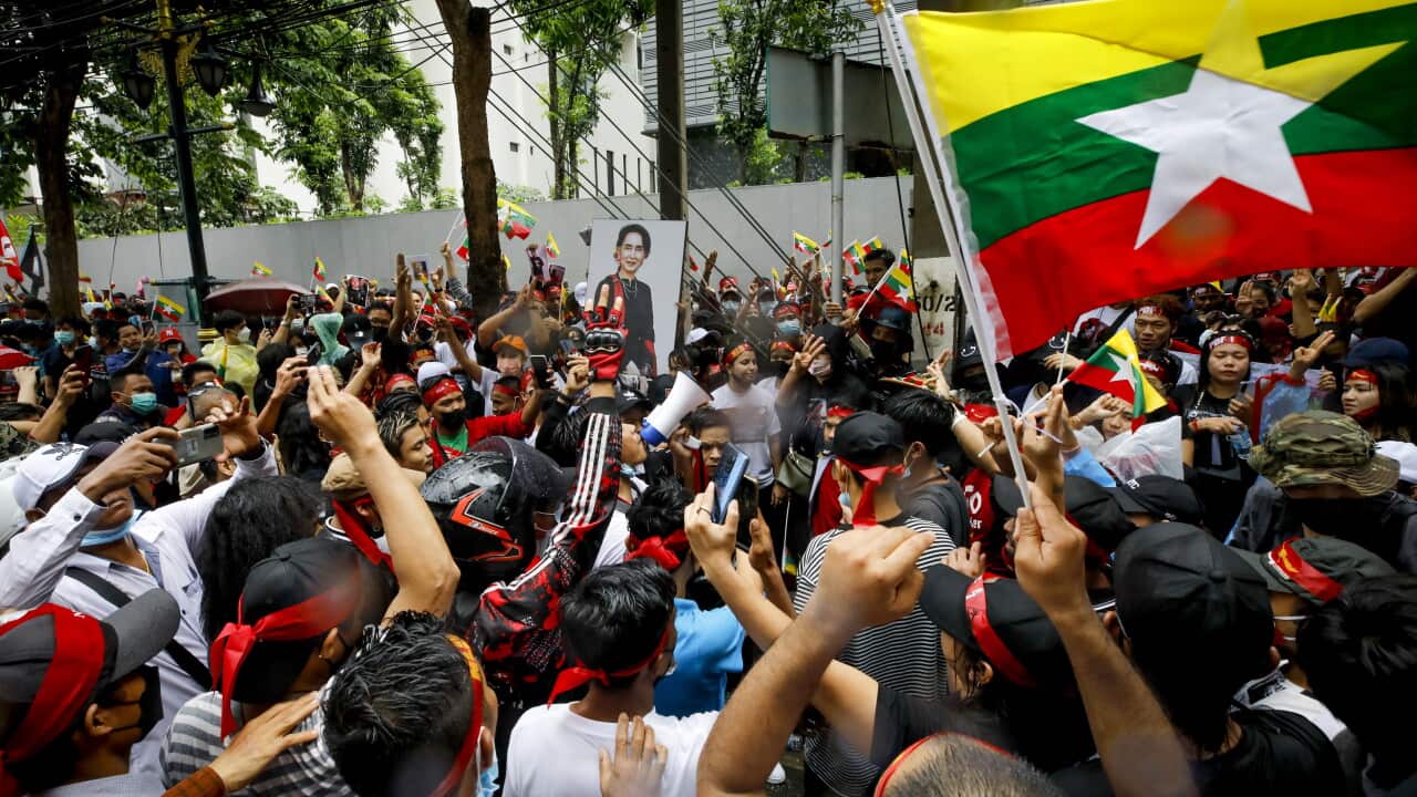 Protestors wave Myanmar's flag in the streets of Thailand