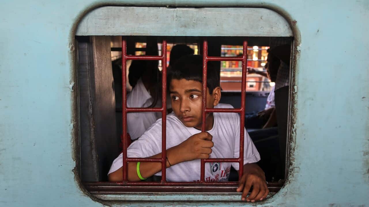 An Indian youth sits in a special chartered train bound for Patna, at the Bandra railway station in Mumbai, India, 18 May 2015.