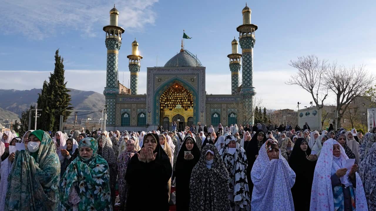 A group of women pray outside a mosque