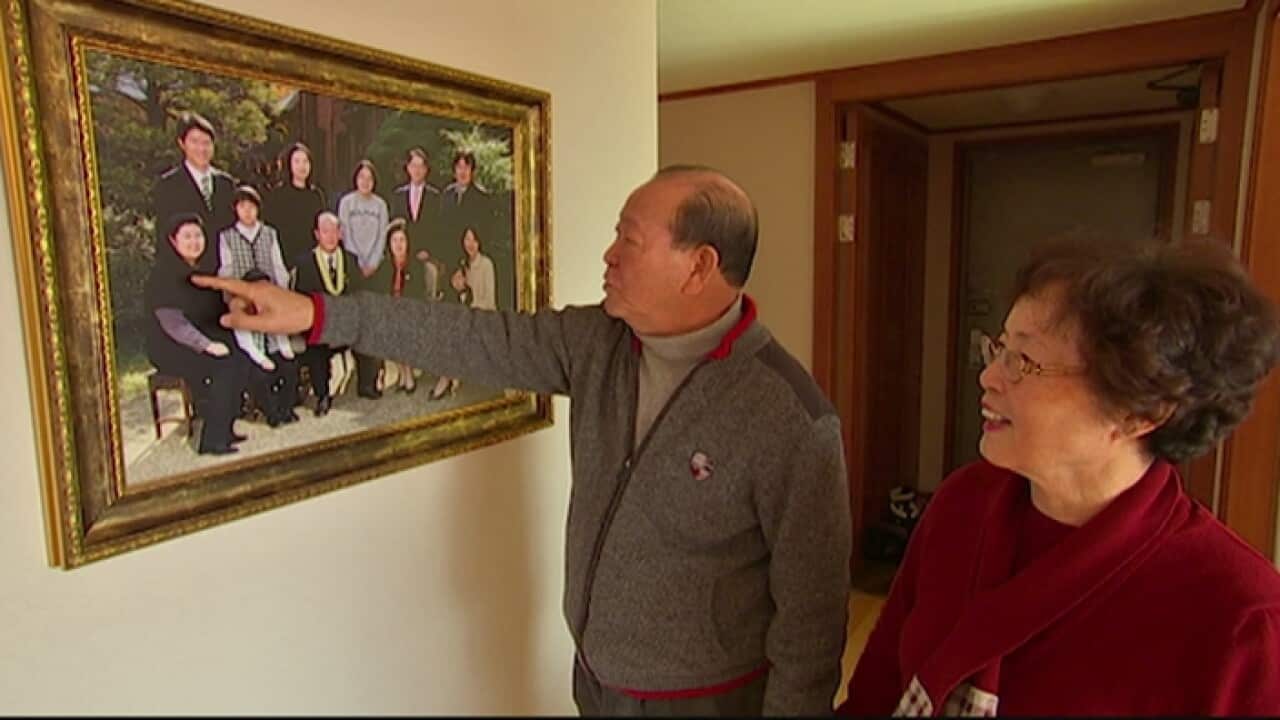 South Korean Yoon Il-Young looking at photos of relatives