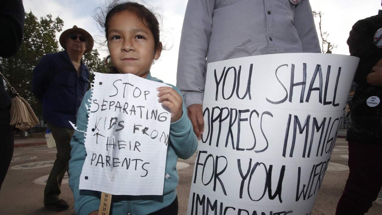 Penny (L), 5 years old, joins protestors at a Los Angeles rally against the Trump administration border policy of separating children in 2018.