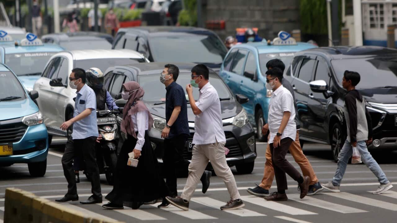 People walk across a main road