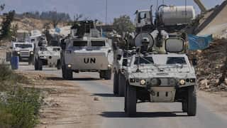 A convoy of white-painted UNIFIL armoured vehicles roll down a dusty road in southern Lebanon.