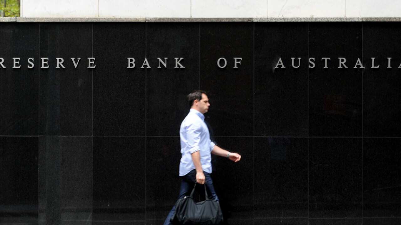 A man walks by the Reserve Bank of Australia.