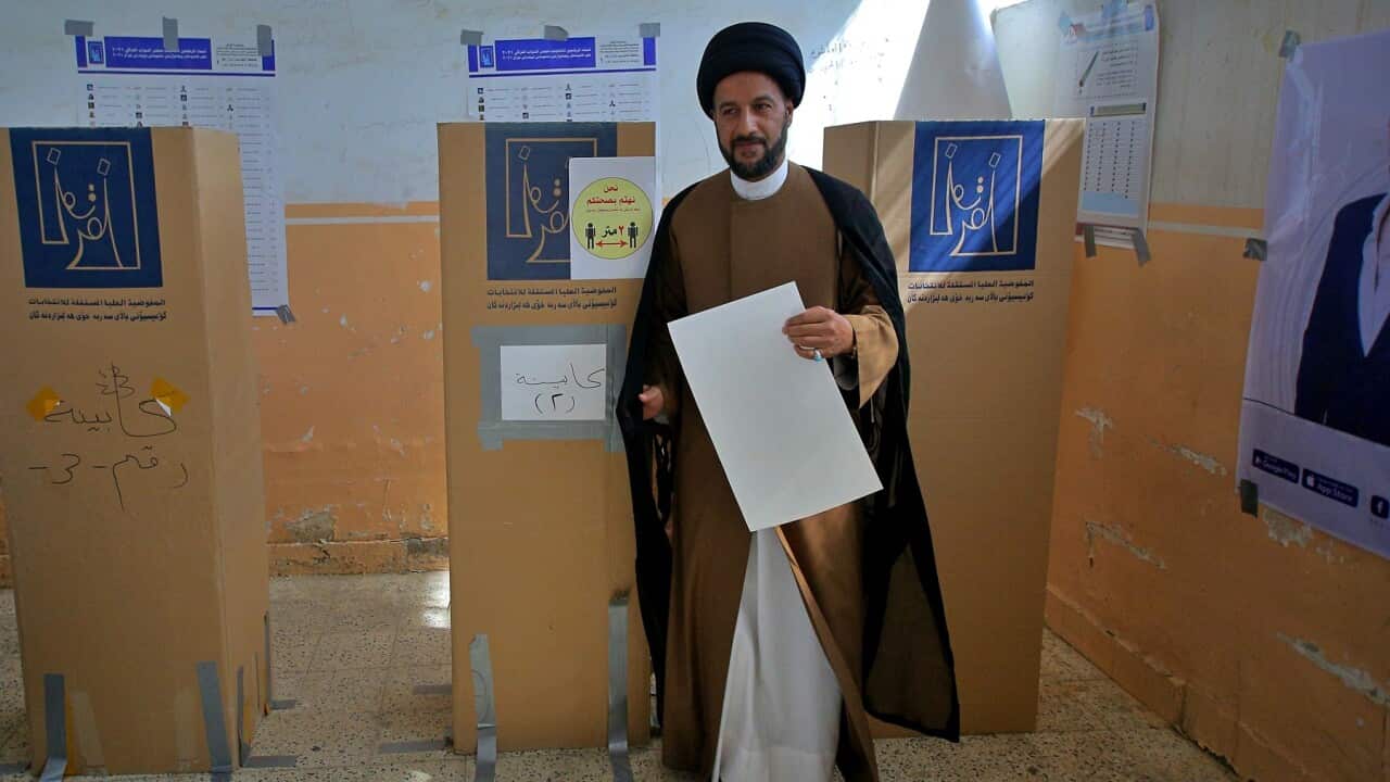 A Shiite cleric casts his vote in Najaf, Iraq