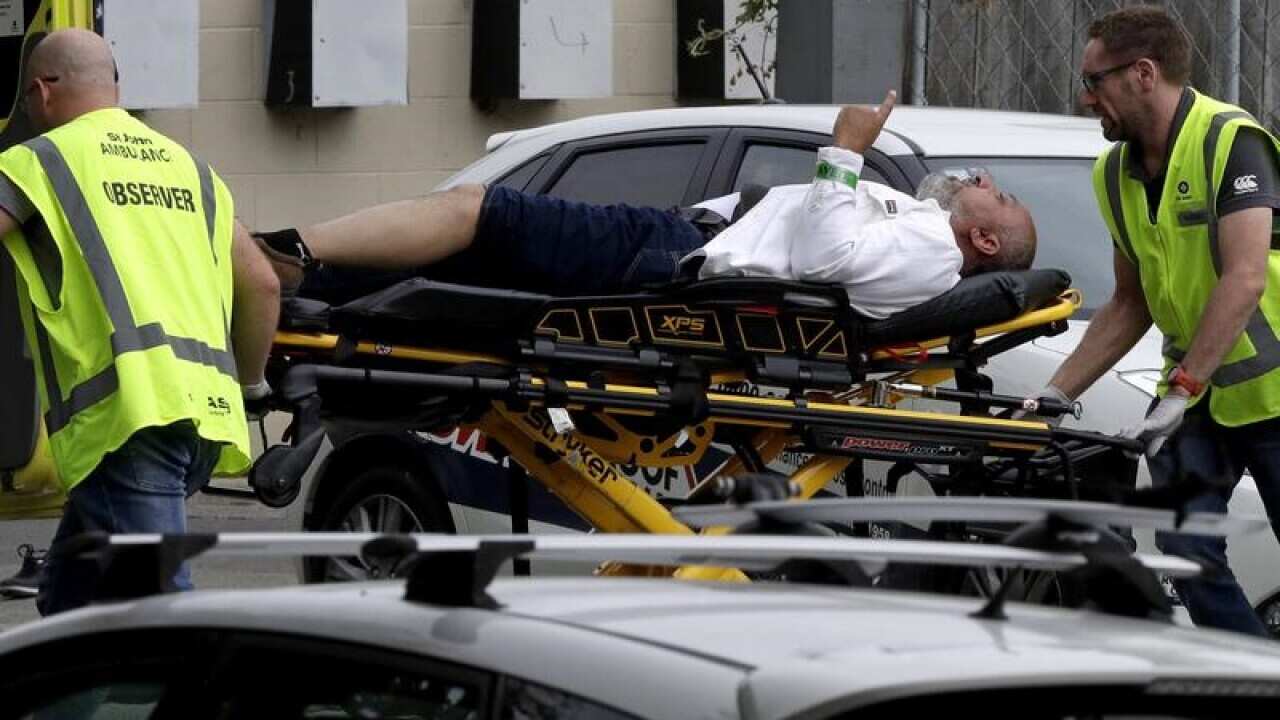 Ambulance staff take a man from outside a mosque in Christchurch