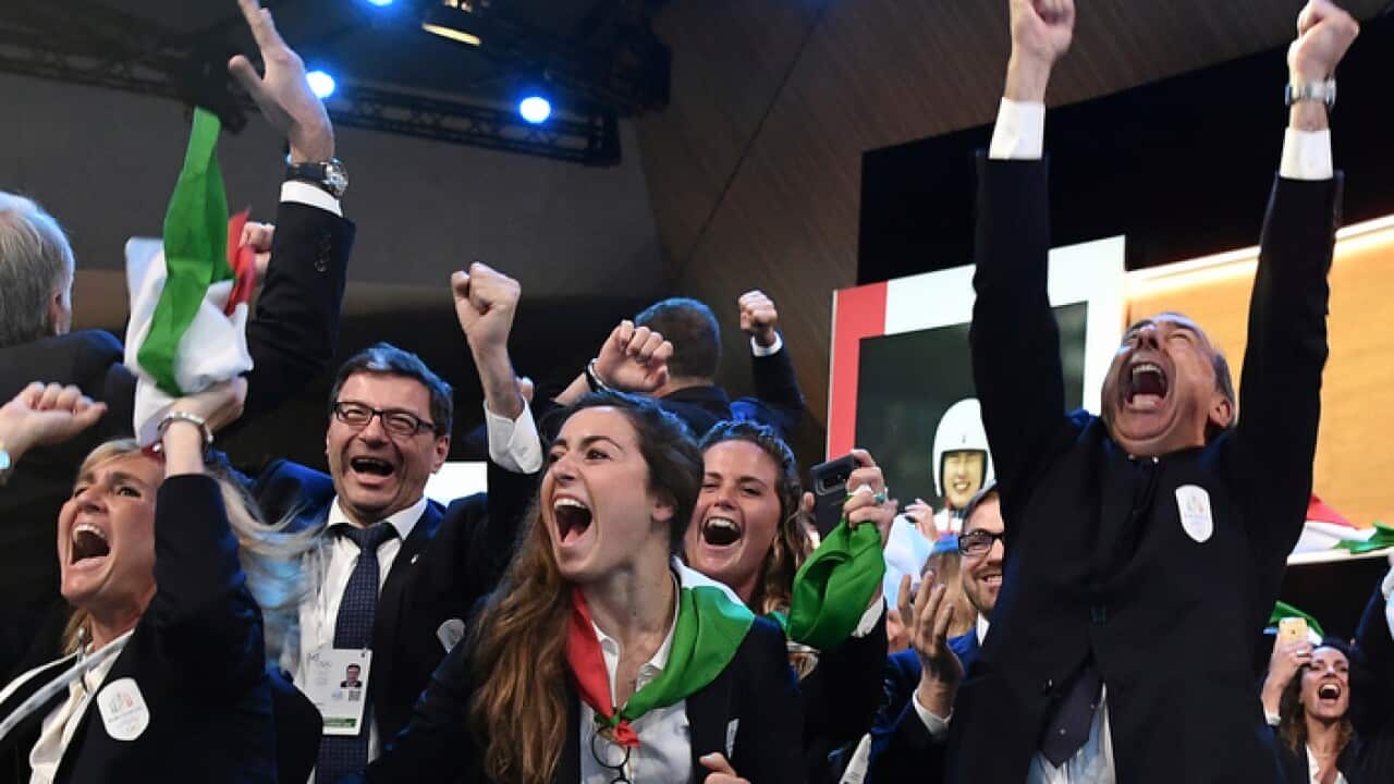 Mayor of Milan Giuseppe Sala, right, and members of Milan-Cortina delegation celebrate after winning the bid to host the 2026 Winter Olympic Games