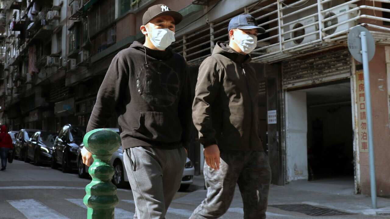 People walk on the street in Macau wearing face masks to protect them to be infected with coronavirus