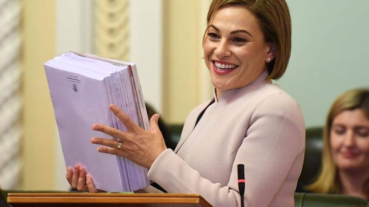 Queensland Treasurer Jackie Trad hands over the budget papers