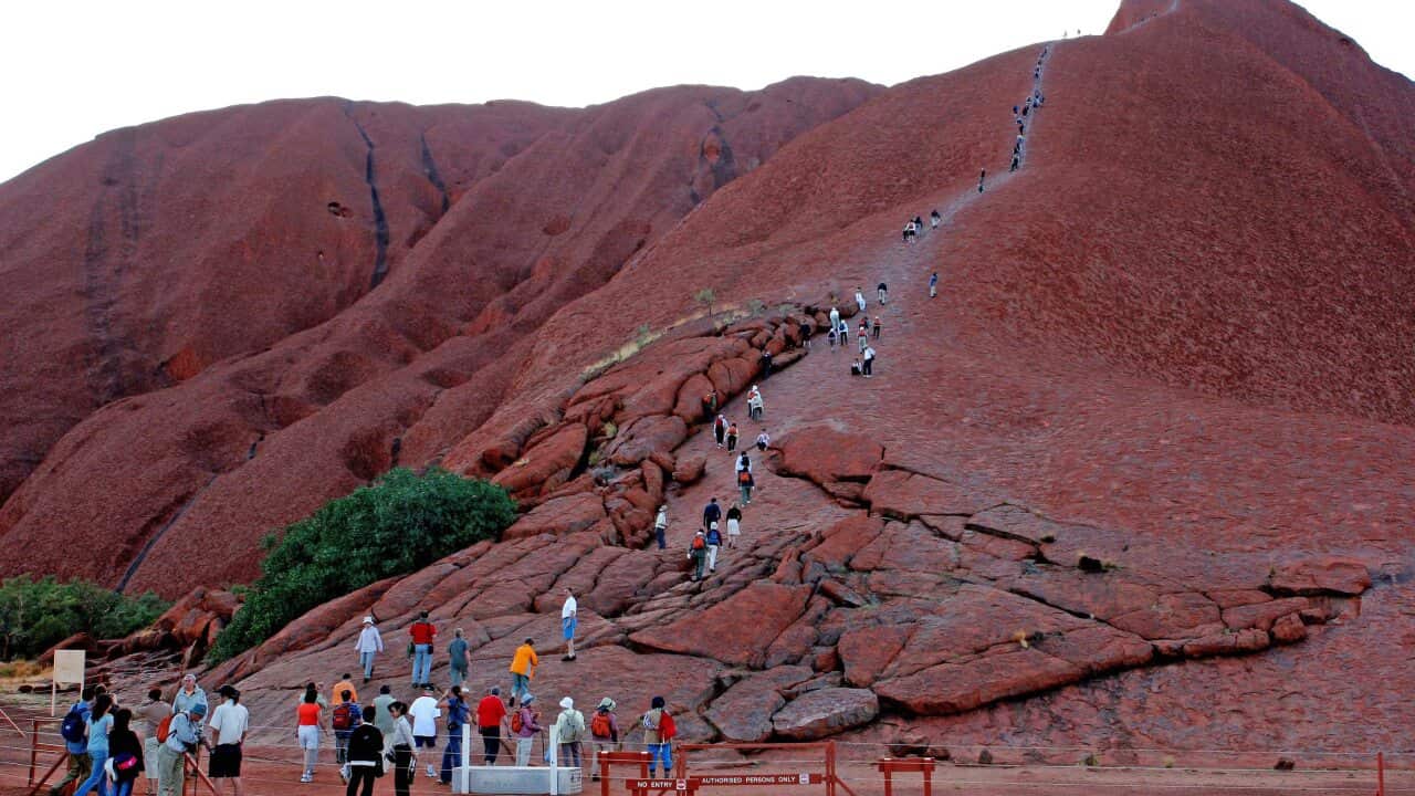 Although against the wishes of the traditional owners, tourists flock to Uluru (Ayres Rock) to climb to the top of the rock, Yulara, Oct. 28, 2006. (AAP Image/Terry Trewin) NO ARCHIVING