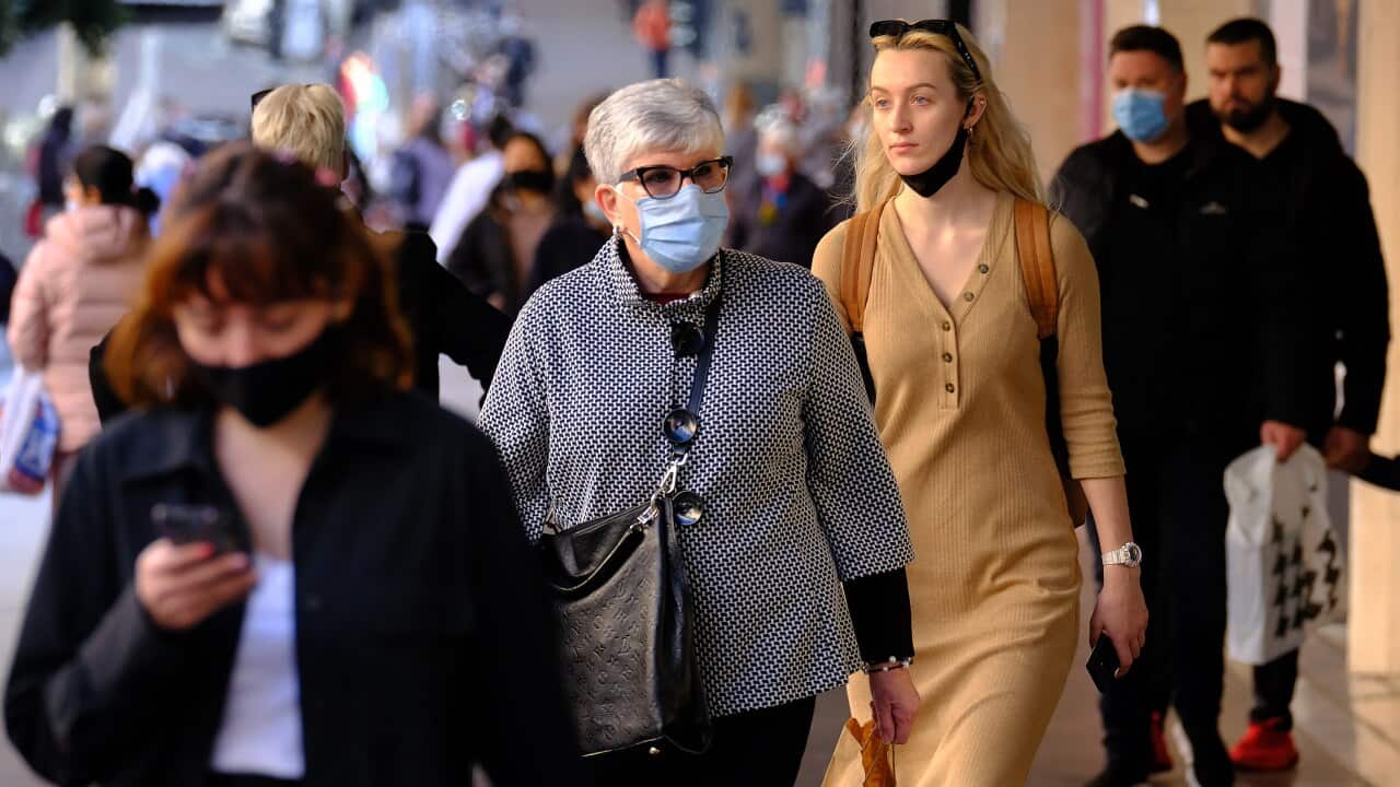 People wearing face masks walk in the Melbourne CBD, Thursday, July 15, 2021. Victoria has reported two new locally acquired COVID-19 cases, on top of the 10 reported in Thursday's official figures. (AAP Image/Luis Ascui) NO ARCHIVING