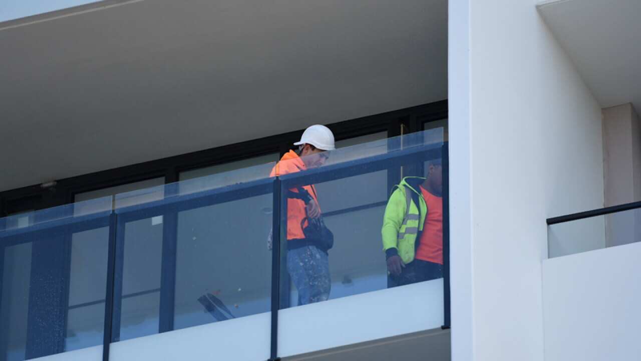 Builders work on new apartments in Melbourne.