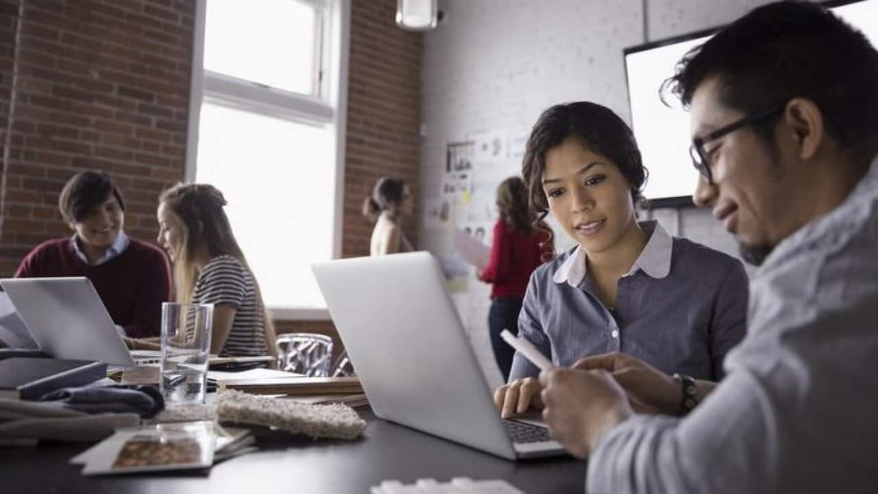 Designers using laptop in conference room meeting