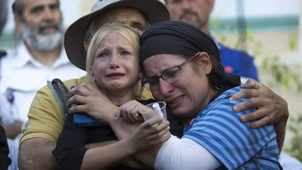 Rina (R), the mother of 13-year-old Israeli girl Hillel Yaffe Ariel, cries with one of her daughters (unidentified) as her husband Michael hugs them