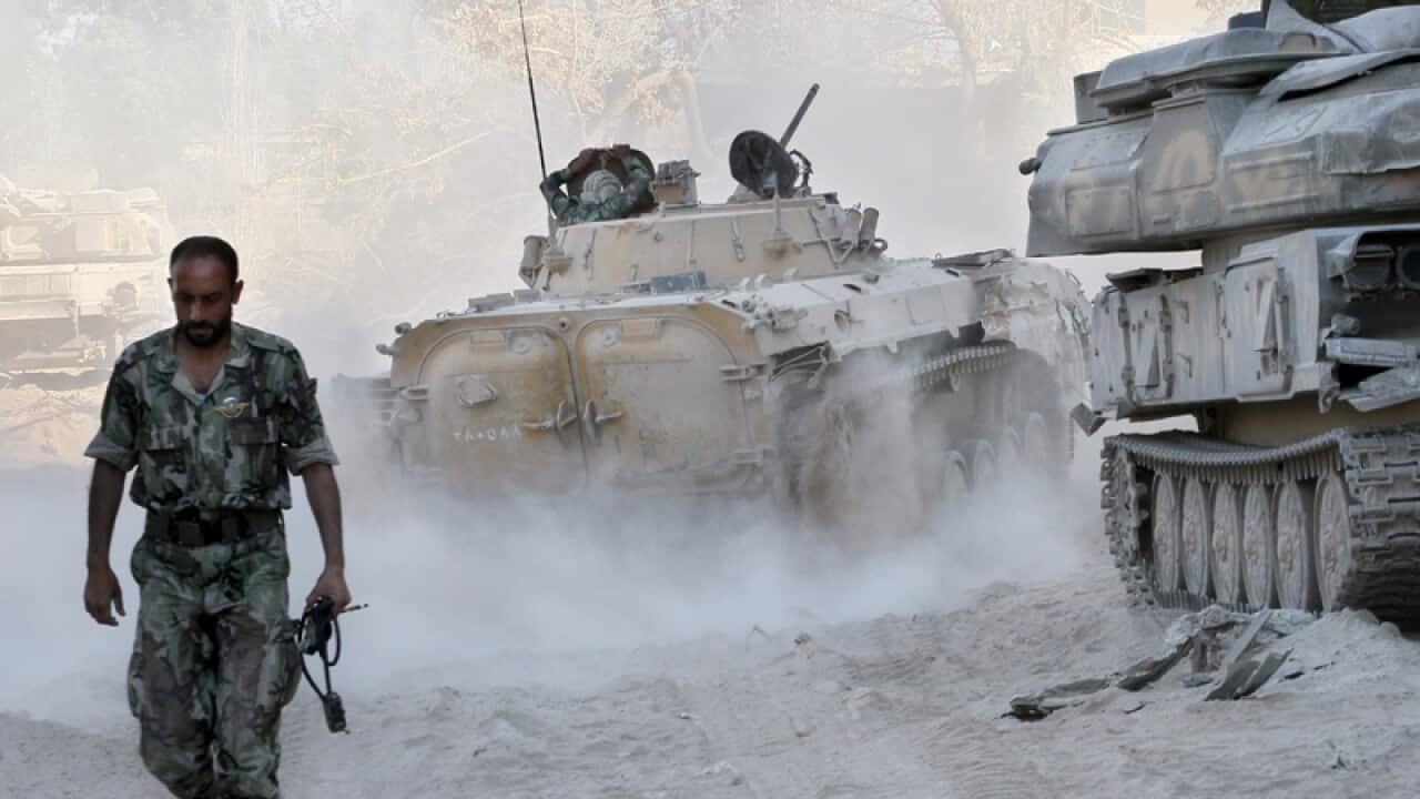 A Syrian army soldier walks on a street.