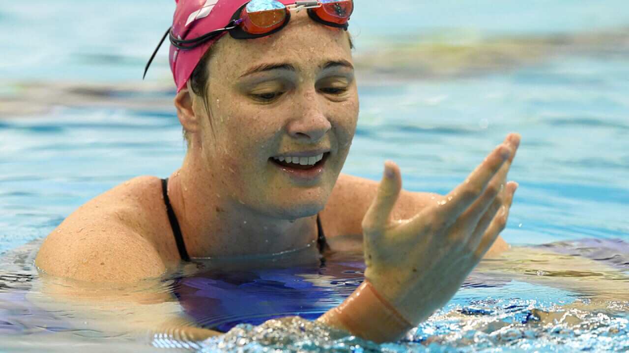 Cate Campbell inspects her strapped wrist