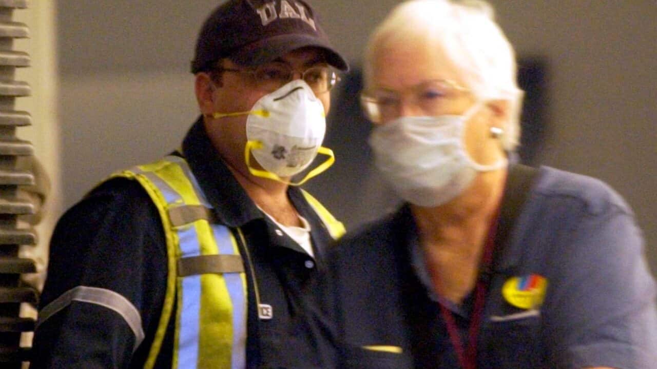 A US airport employee wearing a mask to protect himself from SARS during the 2006 outbreak