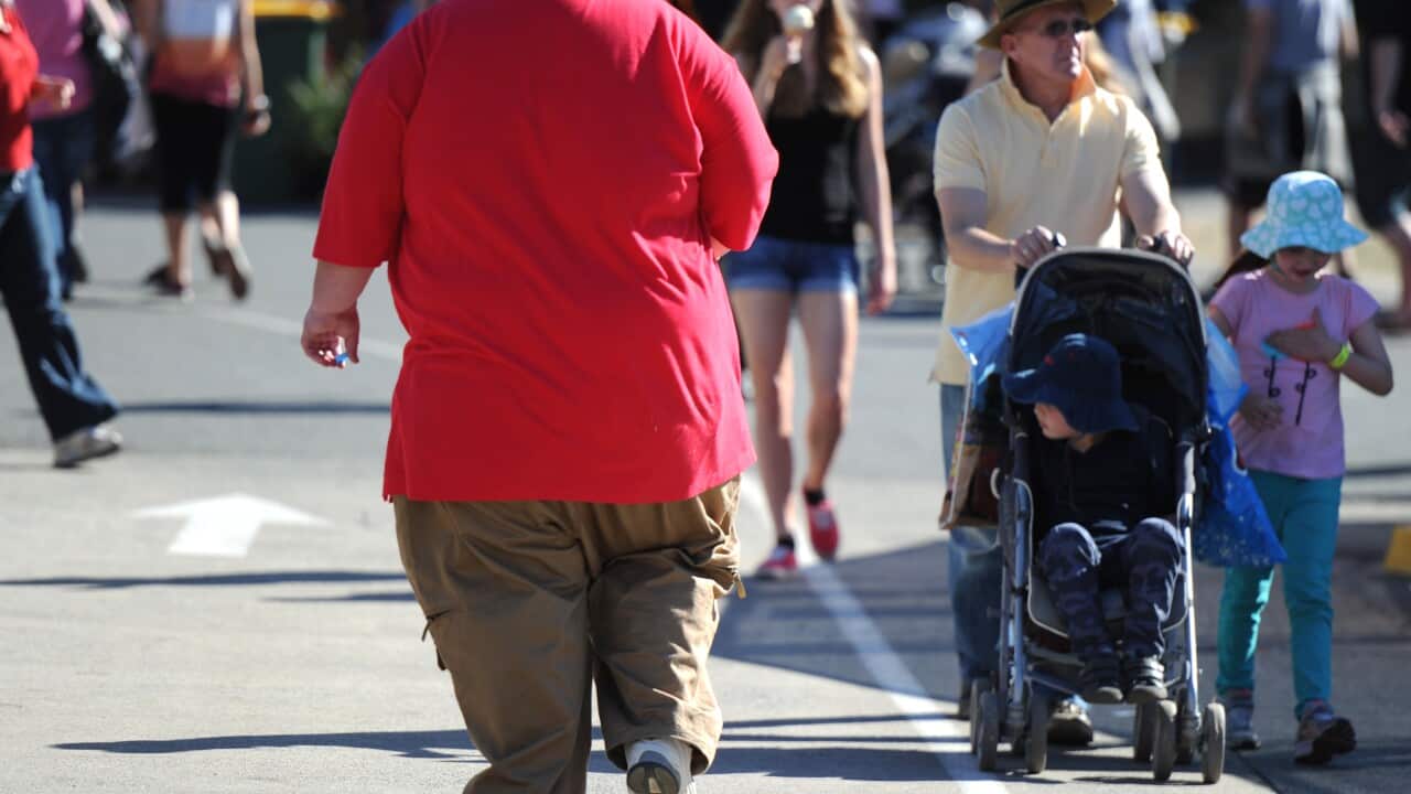 An overweight man walks through Brisbane, Monday, Aug. 12, 2013. (AAP Image/Dave Hunt) NO ARCHIVING