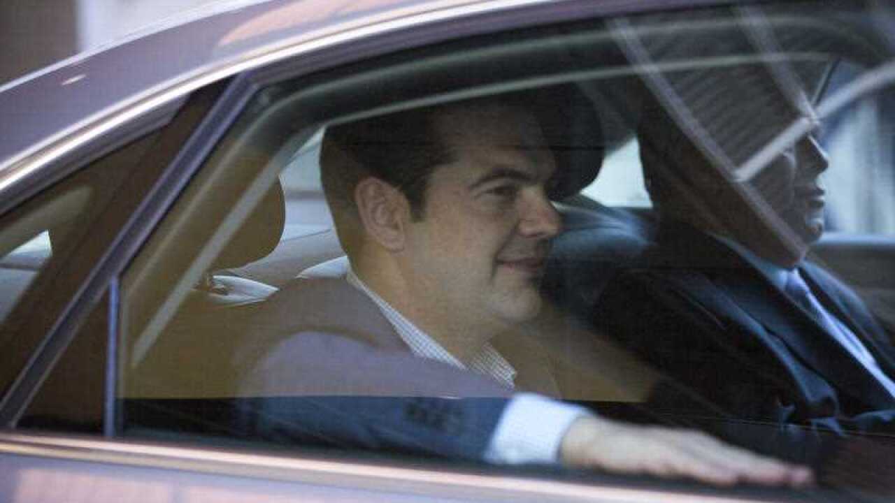 Greek Prime Minister Alexis Tsipras, left, leaves in his car after a meeting at EU headquarters in Brussels on Wednesday, June 24, 2015. Eurozone finance ministers meet Wednesday to discuss the Greek bailout. (AP Photo/Virginia Mayo)