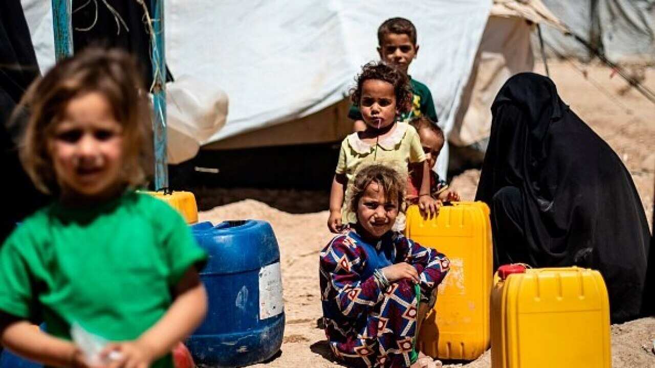 Displaced Syrians queue for water inside al-Hol camp for displaced people in al-Hasakeh governorate in northeastern Syria.