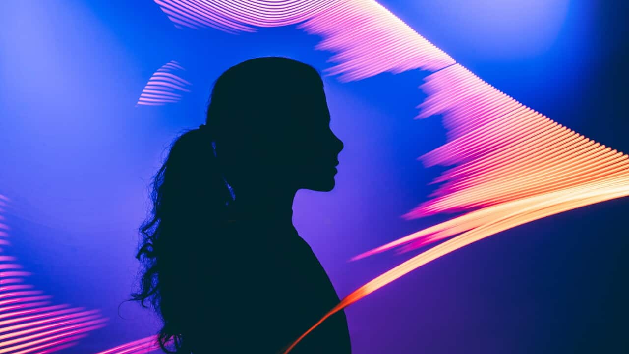 A metaphoric portrait of a human interacting with an AI, illuminated by the facial authentication glow to explore the virtual Universe