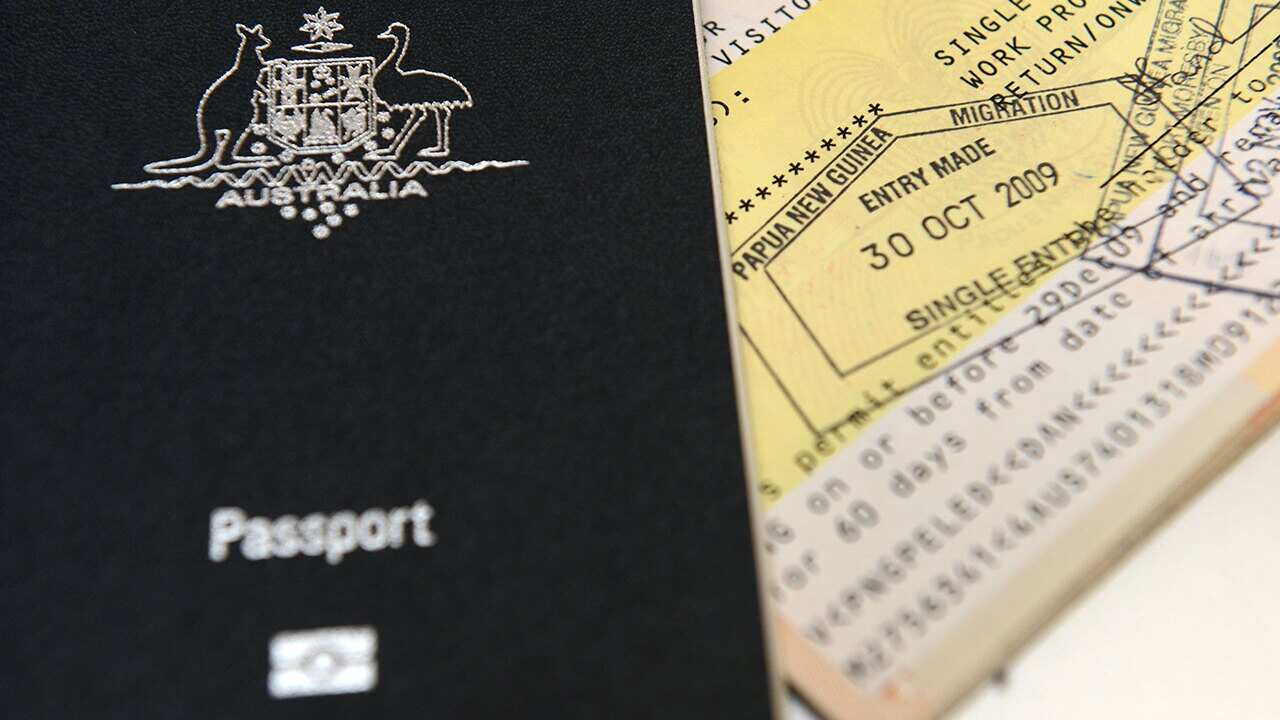 An Australian passport is pictured next to an entry visa to Papua New Guinea in Brisbane.