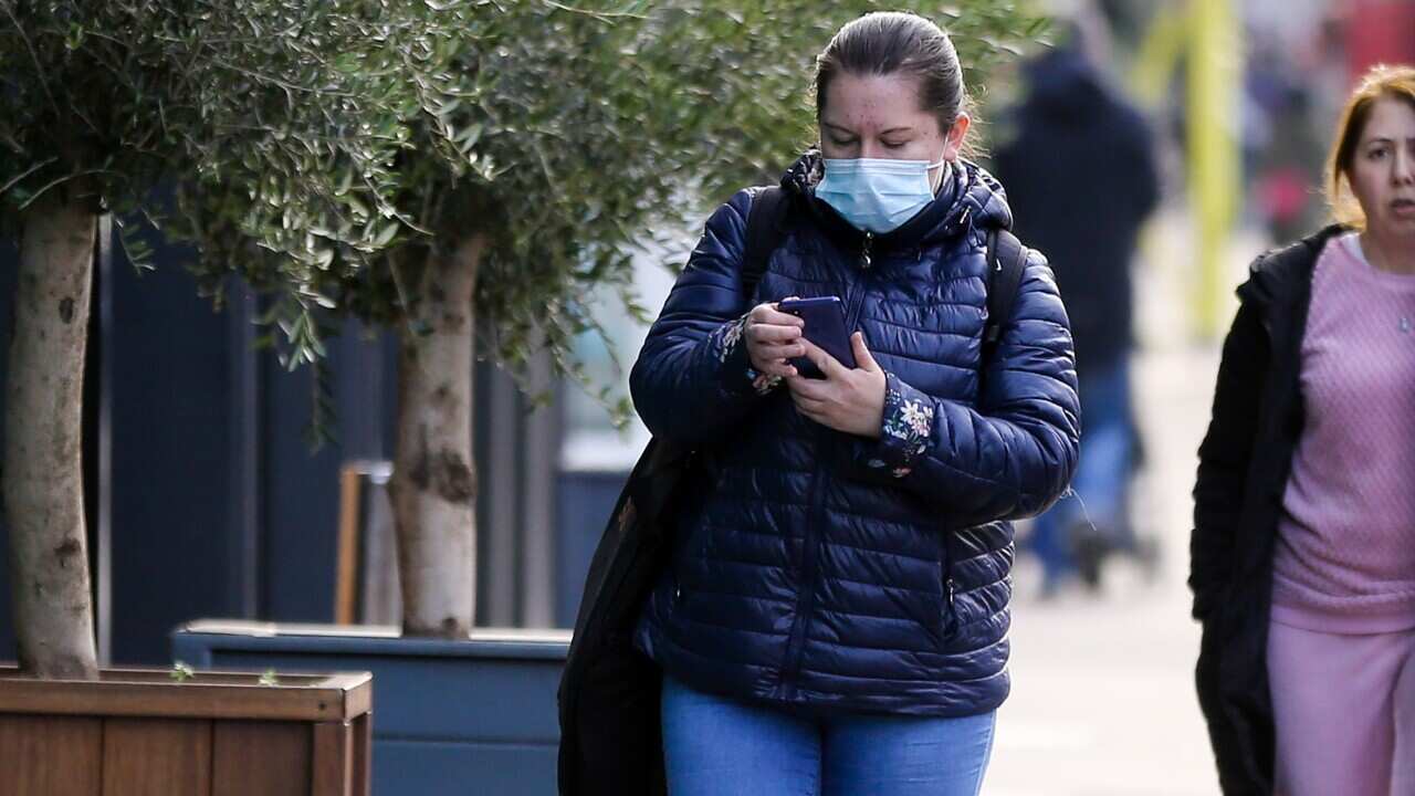 A woman uses her mobile phone on the street.