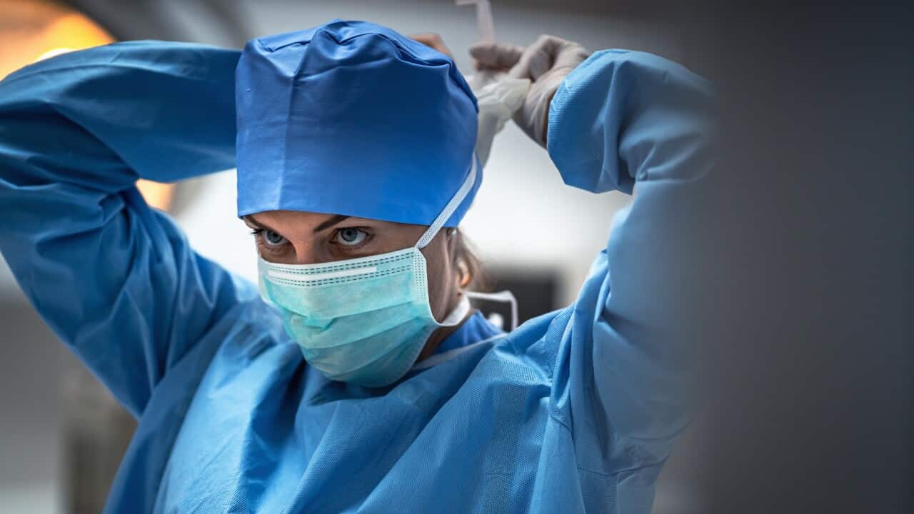The surgeon is wearing a mask to prevent infection before surgery.