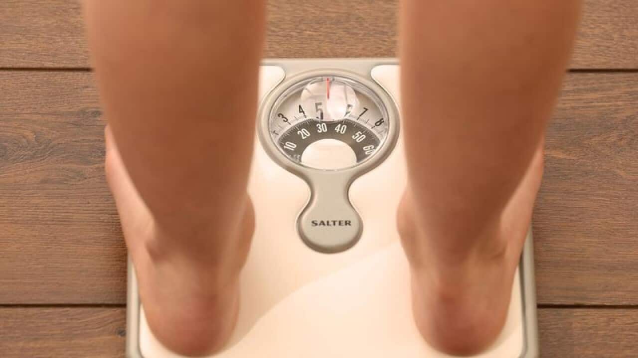 File photo of a model's legs on a weighing scale.