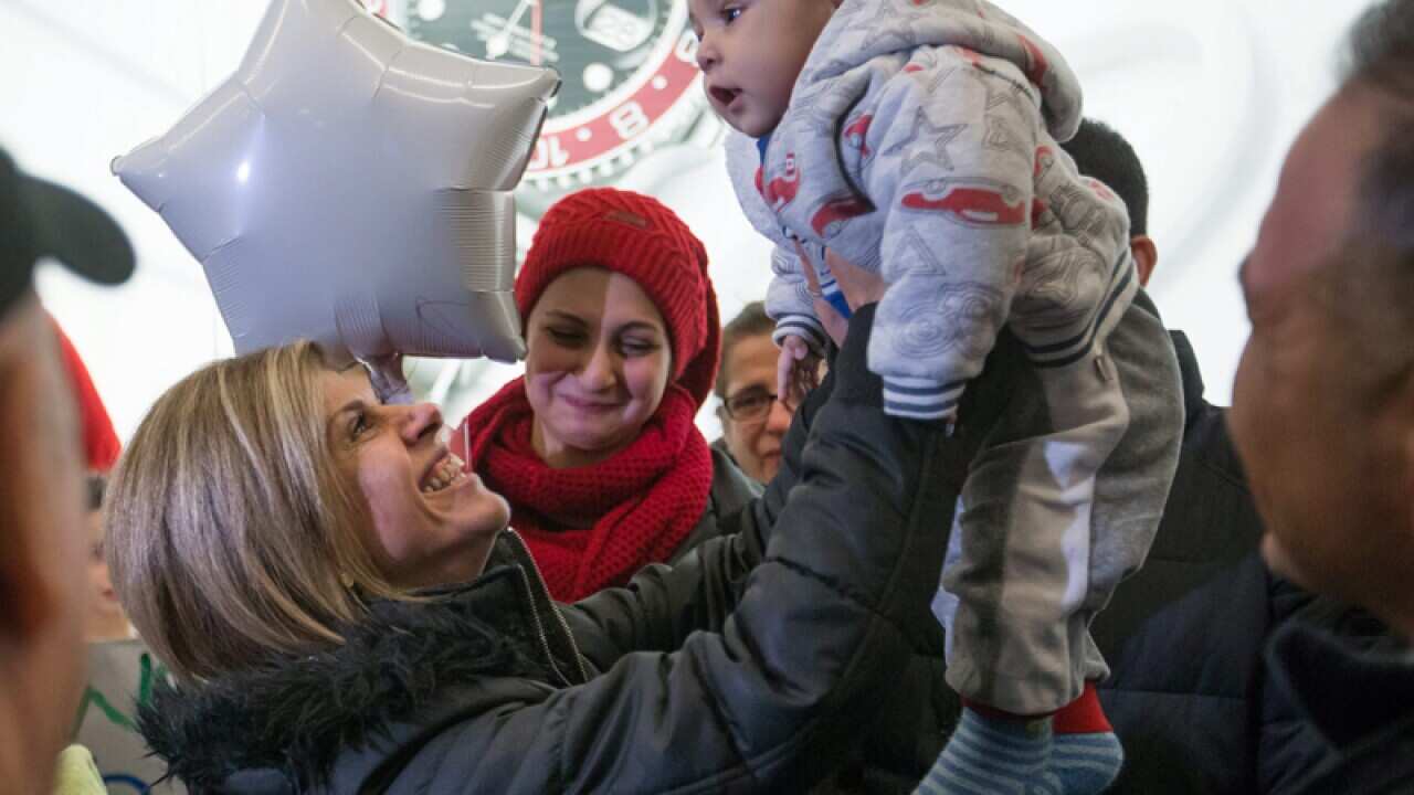 Tima Kurdi, left, lifts up her 5-month-old nephew Sherwan Kurdi