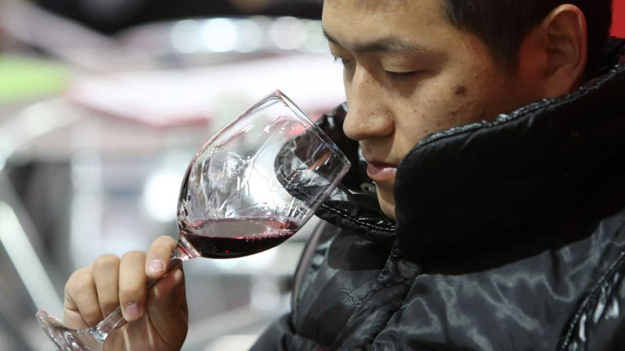 A visitor tastes imported wine at a wine fair in Shanghai, China.