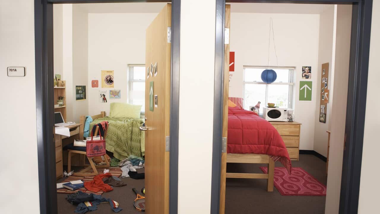 Two university bedrooms are visible, both with their doors open. The one on the left is messy and cluttered, with a green bedspread on an unmade bed, and clothes, books and a tennis racquet on the floor. The bedroom on the right is tidy, with a pink duvet and rug.