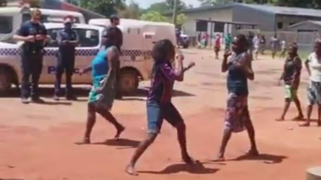 Video footage appears to show Queensland police watching a street fight between two women in Aurukun.